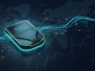 A professional hardware wallet device for secure bitcoin wallets, glowing with cyan light against a dark background of global blockchain networks and financial data.